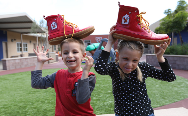 Brother and sister play with Ronald McDonald's size 14 shoes